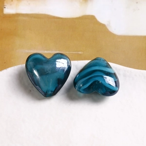 Vista macro di perline a cuore in vetro soffiato blu per creazione gioielli DIY