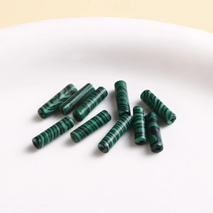 Macro shot of malachite green patterned cylindrical beads for jewelry making