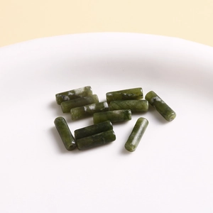 Macro shot of dark green cylindrical natural stone beads with crackle texture for DIY jewelry