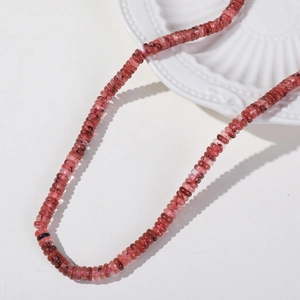 Macro detail of 6mm natural tourmaline abacus beads with rich pink and red textures