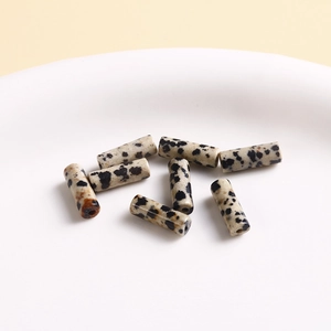 Macro shot of cylindrical natural stone beads with black spots for DIY jewelry