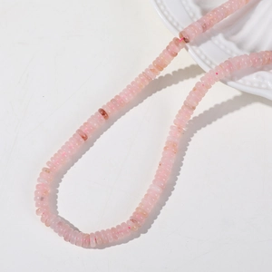 Macro view of 6mm translucent pink quartz rondelle beads for jewelry making