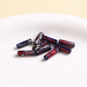Macro detail of cylindrical marble texture beads in deep blue and dark red for DIY jewelry