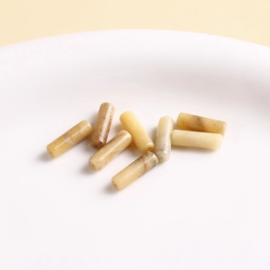 Macro shot of cylindrical natural stone beads in beige and brown for DIY jewelry making