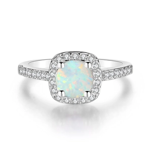 Close-up of silver engagement ring with white opal center stone and zircon accents