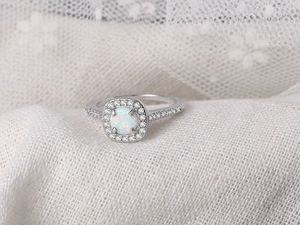 Macro detail of square-cut white opal ring with silver halo and micro-paved zircon stones