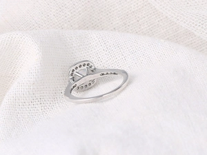 Close-up of a white gold plated opal engagement ring with pavé-set cubic zirconia details