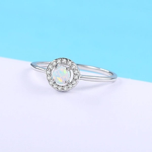 Close-up of white gold plated opal engagement ring with sparkling zircon halo setting