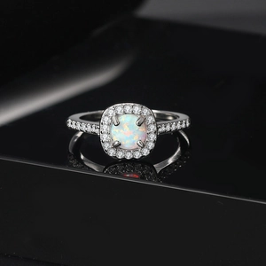 Classic white gold plated opal engagement ring with pavé cubic zirconia on black background