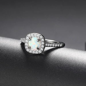 Classic silver-plated engagement ring featuring a cushion-cut opal and halo zircons