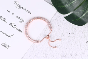 Detail of rose gold tennis bracelet with square zircons and adjustable pull-cord