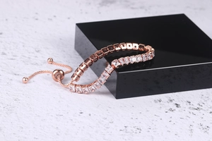 Macro detail of rose gold adjustable tennis bracelet with square-cut cubic zirconia crystals