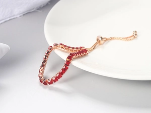 Detail of adjustable rose gold tennis bracelet with red square-cut zircon stones