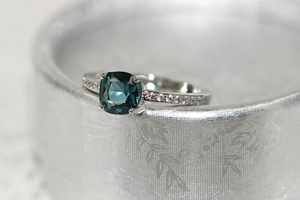 Vue macro détaillée d'une bague avec zircon bleu sarcelle et anneau en micro-pavé