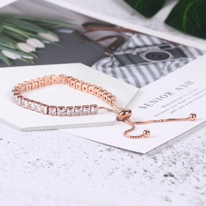 Rose gold adjustable tennis bracelet with 4mm square cubic zirconia on a white tray