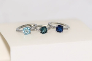 Vue détaillée de trois bagues en argent avec des zircons dégradés bleus alignés