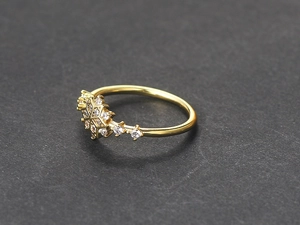 Detailopname van een gouden sneeuwvlok ring met glinsterende zirkonia stenen erop