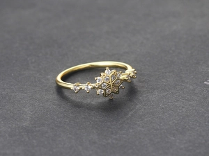Detailopname van de gouden sneeuwvlok ring met micro-pave zirkonia en gepolijste afwerking
