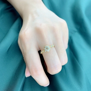 Elegante gouden hexagon sneeuwvlok ring met micro-gezet zirkoon op groen satijnen decor