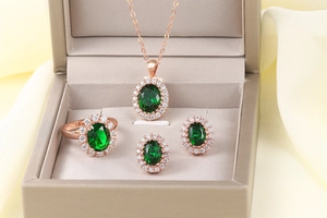 Vista dettagliata del set gioielli halo verde smeraldo con collana, anello e orecchini oro rosa