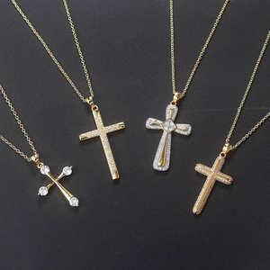 Quattro collane a croce in oro e argento con micro-pave di zirconi su sfondo nero