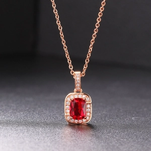 Macro detail of rectangle red ruby halo pendant with rose gold and small zircon accents