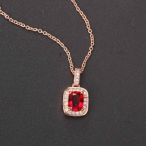 Macro shot of rose gold necklace featuring square red gemstone with zircon micro-paving