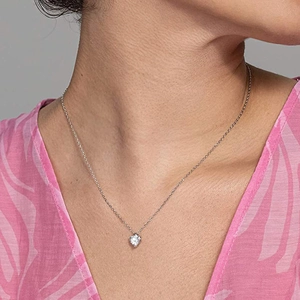 Elegante zilveren ketting met hartvormige zirkoon hanger getoond op een model