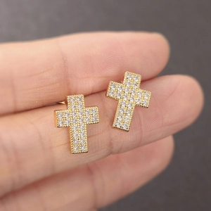 Hiphop gold plated cross stud earrings with full cubic zirconia held in hand
