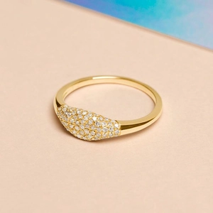 Détail de bague plaquée or 14k avec micro-pavé de zircons sur une surface en navette