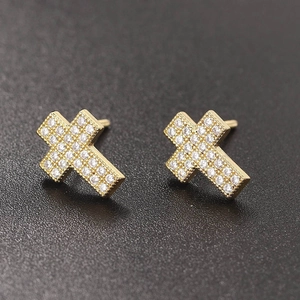Macro view of gold cross stud earrings featuring micro-pave set sparkling white zircons