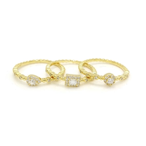 Detaillierte Nahaufnahme eines dreiteiligen Gold-Stapelring-Sets mit klaren Zirkonia-Steinen
