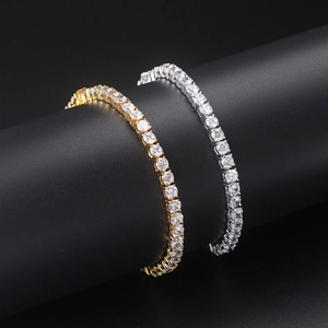 Close-up of gold and silver single row tennis bracelets with cubic zirconia on black stand