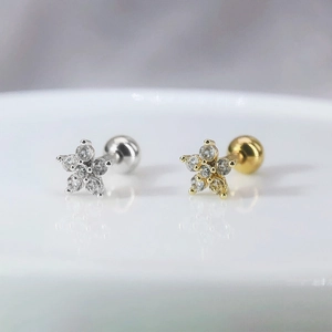 Gros plan de boucles d'oreilles fleur en zircon, finitions argentée et dorée élégantes