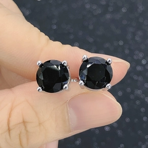 Close-up of classic silver four-prong earrings with round black cubic zirconia stones