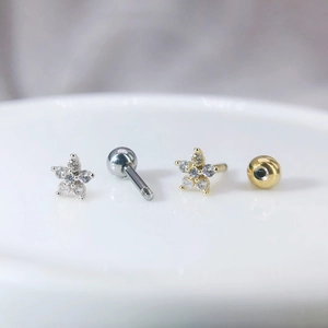 Vue macro de clous d'oreilles fleur en zircon micro-serti en tons or et argent