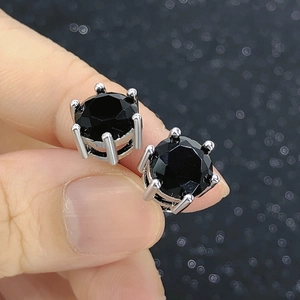 Macro shot of a classic six-prong stud earring featuring a black round-cut cubic zirconia