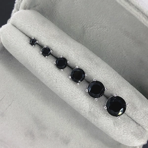 Detail of six pairs of black cubic zirconia stud earrings in classic four-prong settings