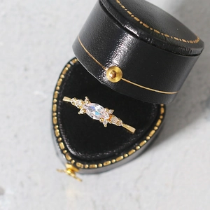 Close-up of gold ring with marquise-cut zircon in a luxury vintage leather jewelry box