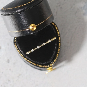 Close-up of minimalist gold ring with seven micro-pave zircons in a heart-shaped box