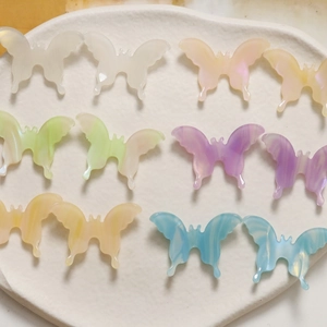 Detailed view of colorful 3D acetate butterfly charms with marble texture for DIY jewelry