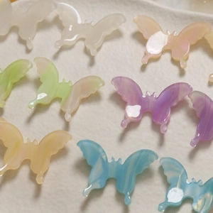 Flat lay of colorful 3D acetate butterfly charms with marble texture for jewelry DIY
