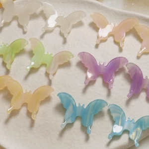 Close-up of colorful gradient butterfly charms with marble texture for DIY jewelry making