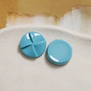 Close-up of 20mm blue resin windmill shaped round charms for DIY jewelry making