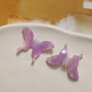 Macro detail of 3D gradient purple acetate butterfly charms for DIY jewelry making