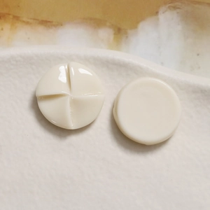 Macro detail of 20mm off-white resin windmill charms for DIY phone case decoration