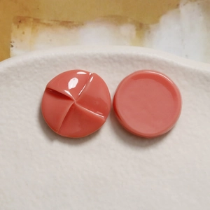 Detailed macro view of coral resin round charms with swirl and smooth surface finishes