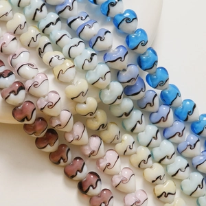 Vue macro de perles en verre de 15 mm en forme de cœur avec motifs à rayures colorées