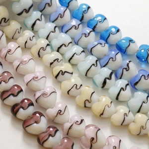 Détail macro de perles en verre en forme de cœur 15mm avec motifs à rayures peints à la main