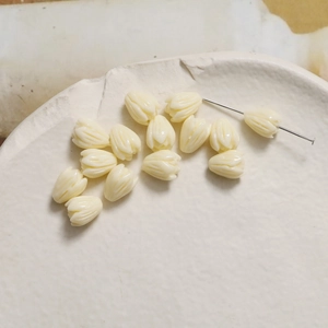 Detail of cream tulip bud resin beads with fine petal texture and piercing hole